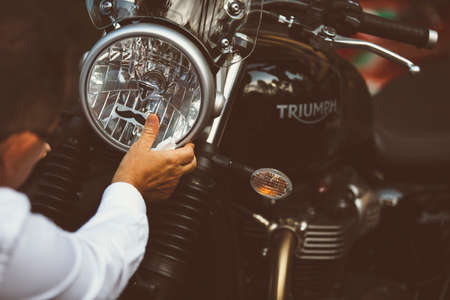 ALICANTE, SPAIN - SEPTEMBER 25, 2016: Detail of the hand of a man is putting a moustache sticker on the headlight of his motorcycle on the Distinguished Gentleman's Ride day, a global fundraiser for prostate cancer and men's health investigation.のeditorial素材