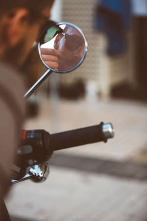 ALICANTE, SPAIN - SEPTEMBER 25, 2016: Reflection in the rearview mirror of a stylish motorbike racer are grooming his moustache on the Distinguished Gentleman's Ride day, a global fundraiser for prostate cancer and men's health investigationのeditorial素材