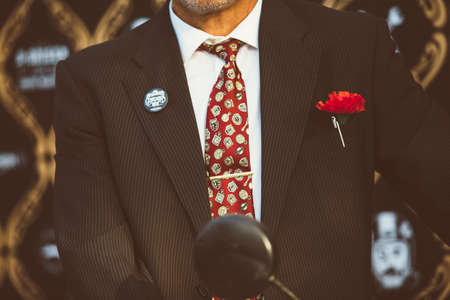 ALICANTE, SPAIN - SEPTEMBER 25, 2016: Cropped view of a motorbike racer are sitting on his moto with a flower in the pocket of his jacket on the Distinguished Gentleman's Ride day, a global fundraiser for prostate cancer and men's health investigationのeditorial素材