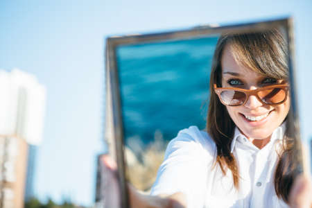 Portrait of brunette beautiful woman with sunglasses in mirror reflectionの写真素材