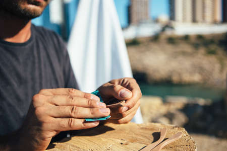 Close up of unrecognizable male master treats handmade wooden blank of sunglassesの写真素材