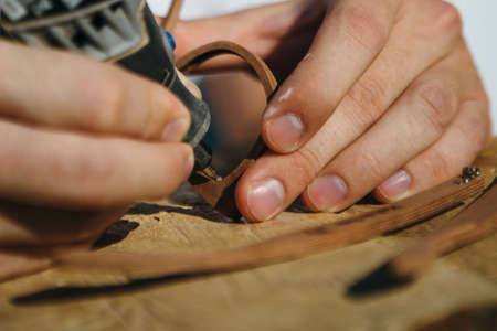 Close up of treating wooden frame of sunglasses with sanderの写真素材