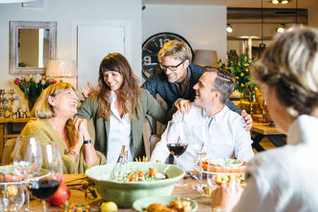 Lovely friends hanging out at celebration table.の写真素材