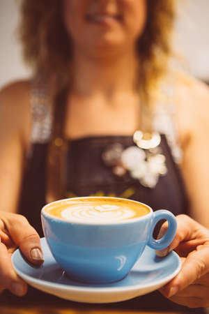 Close-up of tasty latte art in blue cup on saucer.bokehの写真素材