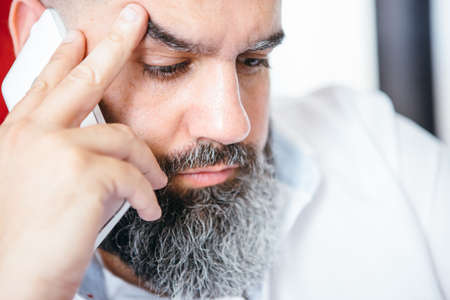 Bearded businessman calling over cell in close-up
