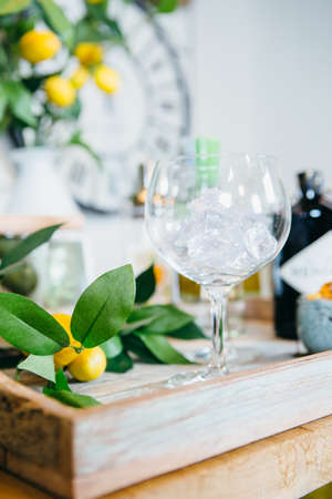 Close up cocktail glass with ice and tangerines aside on wooden tray.の写真素材