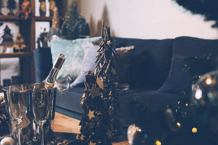 View of living room decorated to Christmas with table served with champagne and small decorative fir tree. の写真素材