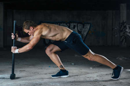 Man doing hard train work with sledgehammer. Horizontal indoors shotの写真素材