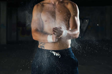 Sportsman covers his hands with chalk. Horizontal indoors shotの写真素材