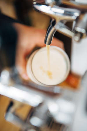 Blur of froth beer pouring from crane
