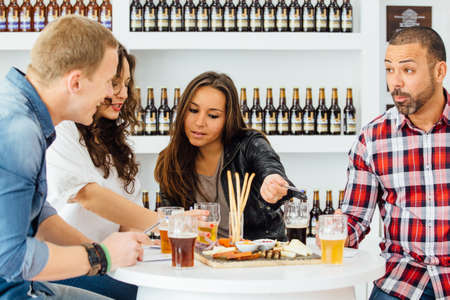 Adult men laughing while women talking about beerの写真素材