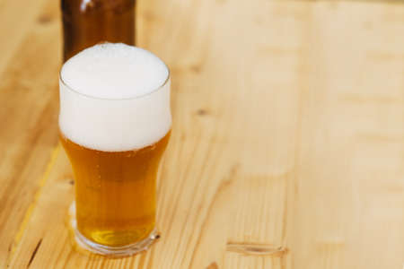 Close-up of light craft beer in glass on tableの写真素材