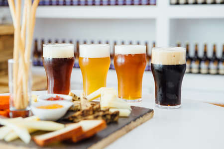 Close-up of four glasses of different craft beer with snack boardの写真素材