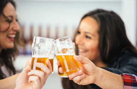 Close-up of cheering glasses and two smiling women on background