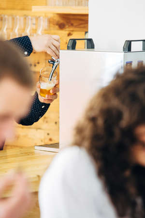 Mans hands pouring glass with craft beer