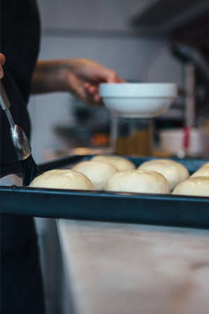 Close-up of unrecognizable woman brushing buns with butterの写真素材