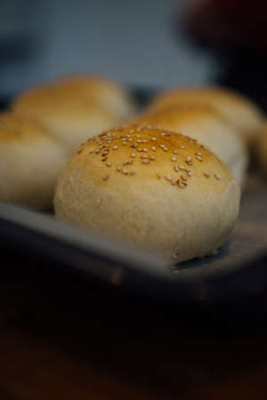 Close-up of tasty crunchy bun with sesame on oven trayの写真素材