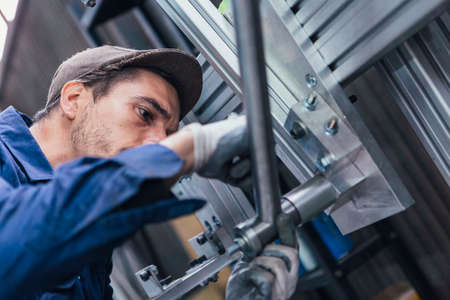 Close-up of bearded man in cap working with iron detailsの写真素材