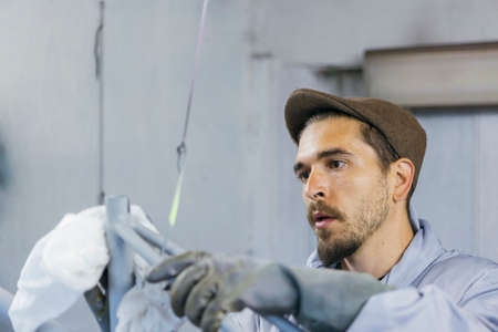 Bearded man cleaning bicycle frame with white towelの写真素材