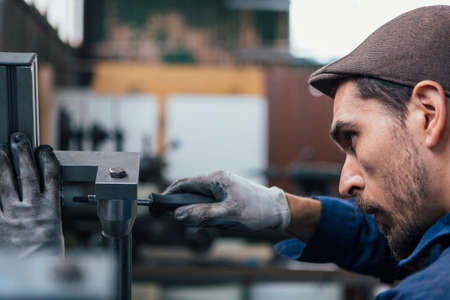 Bearded craftsman using screwdriverの写真素材