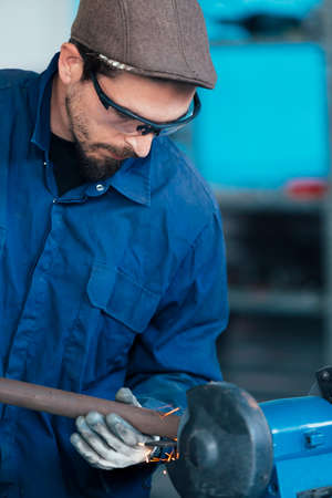 Bearded craftsman working with metalの写真素材