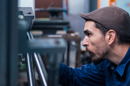 Bearded craftsman measuring metal detailsの写真素材