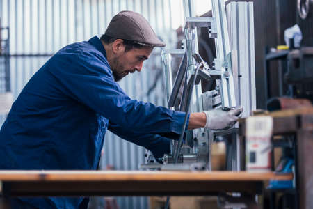 Side view of bearded professional worker looking at iron details