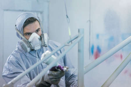 Close-up of adult professional painter in process of painting frameの写真素材