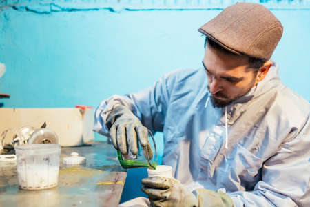 Bearded craftsman pouring green colorの写真素材