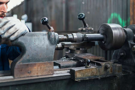 Craftsman working with iron lathe in motionの写真素材
