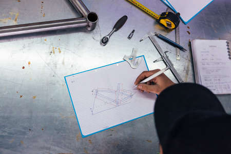 Professional craftsman doing drawing with pen of bicycle