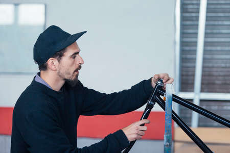 Bearded man working with metal bars
