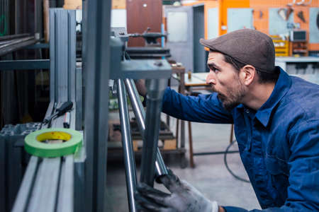 Bearded man taking measurements with green tapeの写真素材