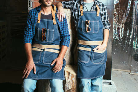 Crop faceless shot of two workers in uniform posing with sunglasses on pockets.の写真素材