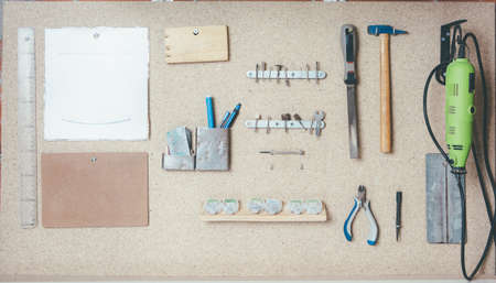 Various working tools hanging on wooden board in workshop.の写真素材