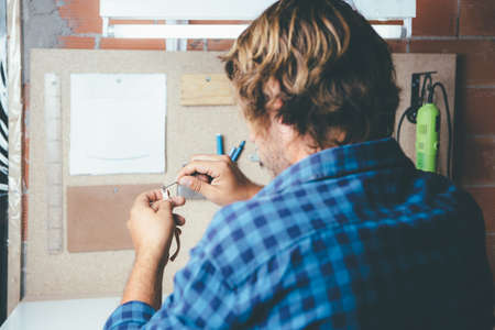 Back view of artisan producing rim for glasses at workshop.の写真素材