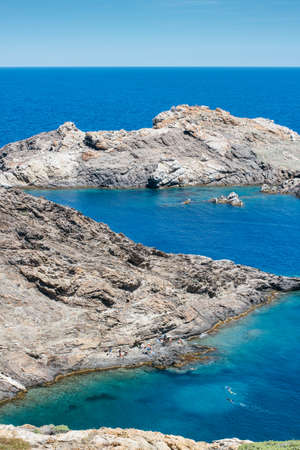 Vertical outdoors shot of big rocks placed at blue peaceful ocean.の写真素材