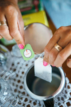 Hands of woman making a cup of tea with teabag.の写真素材