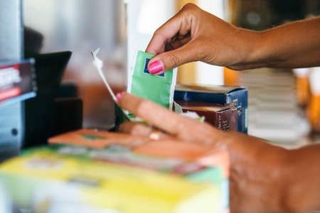 Horizontal indoors shot of woman taking teabag from box.の写真素材