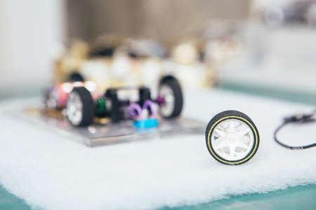 Horizontal close-up shot of table with wheel and handcrafted slot car under construction.の写真素材