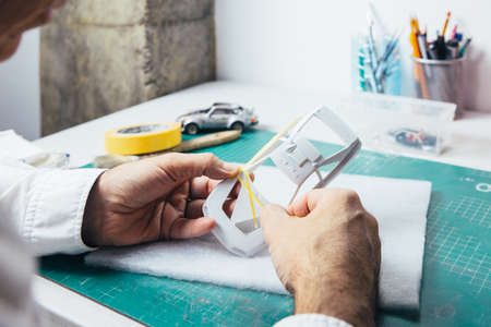 Unrecognizable person using sticky tape for paint a slot car.の写真素材
