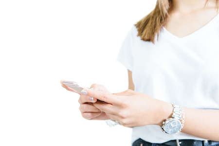 Crop shot of young casual girl holding and using smartphone isolated on white.の写真素材