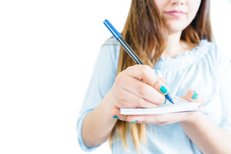 Crop girl holding notepad and writing with pen on white background. 
