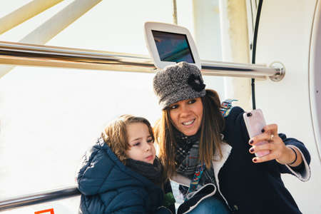 Mother and son making selfie from a capsule of the London Eye Wheelの写真素材