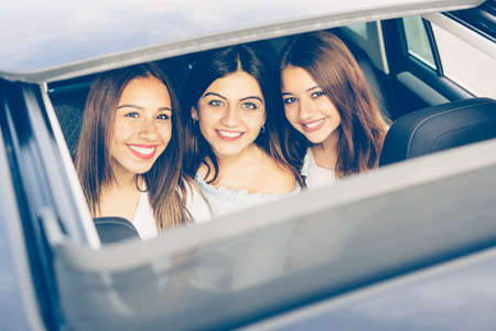 Top view of a happy group of girls friends through the top window of a car