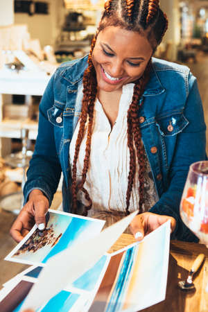 Cropped view of smiling young mixed race woman photographer working at office choosing photosの写真素材