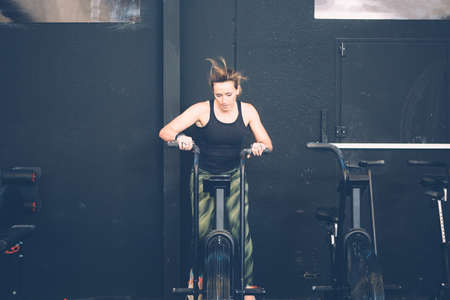 Young sporty woman doing calorie assault exercise on a cross-fit routine at the box gymの写真素材