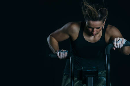 Close up of a front view of a young sporty woman doing calorie assault exercise on a fitness routine at the box gym. Copy space area availableの写真素材