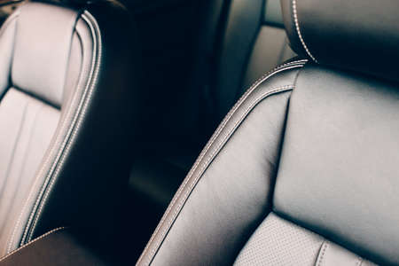 Cropped view of a detail of black leather handmade upholstered seats of a chic car