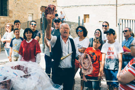 PUERTOMINGALVO, TERUEL, SPAIN - AUGUST 5, 2018: Man is making a pork meat auction in a medieval fair celebrated in Puertomingalvo, a small town located in the Maestrazgo Cultural Park in the region of Gudar Javalambre, in the province of Teruel, Aragon, Sのeditorial素材
